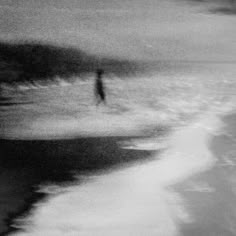 a blurry photo of a person walking on the beach