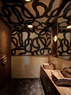 an artisticly designed bathroom is shown in this image, with two sinks and mirrors on the wall