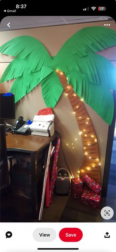 a palm tree made out of paper on top of a desk next to a computer