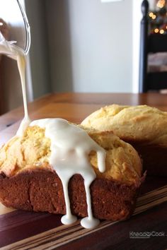 a loaf of bread with icing on it sitting on top of a wooden table