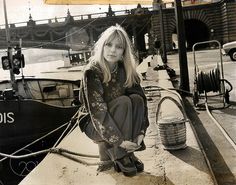 a woman sitting on the side of a boat next to a roped in area