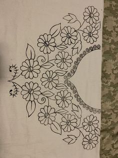 a black and white drawing of flowers on a piece of cloth with a camouflage background