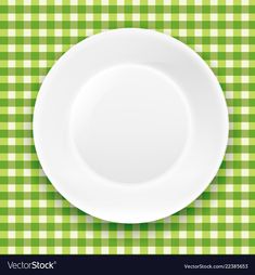 a white plate on a green checkered tablecloth with place for your text or image