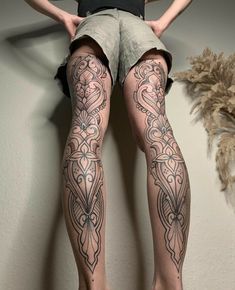 a woman's legs with tattoos on them