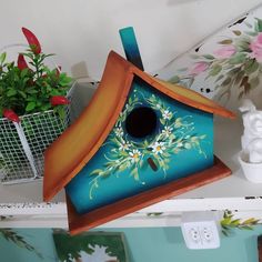 a blue birdhouse with flowers painted on it