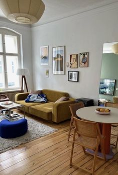 a living room filled with furniture next to a wooden table and chairs in front of a large window