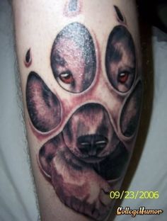 a dog's paw with red eyes is shown in this tattoo design on the leg