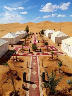 an aerial view of several tents in the desert with red and white designs on them