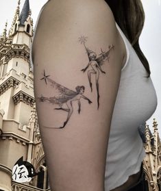 a woman's arm with two fairy tattoos on it