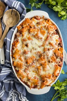 a casserole dish with meat and cheese in it on a blue tablecloth