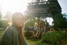 a woman standing in front of the eiffel tower with her family behind her