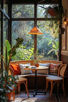 a corner table with two chairs in front of a large window that has plants on it