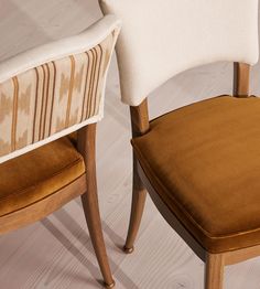 two chairs sitting next to each other on top of a wooden floor