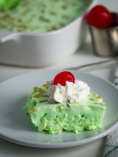 a piece of cake sitting on top of a white plate next to a bowl of pudding