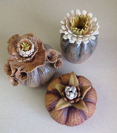 three vases with flowers in them sitting on a table