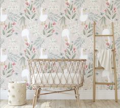 a baby's crib in front of a wallpaper with flowers and leaves