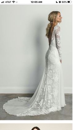 a woman in a wedding dress standing against a wall with her back to the camera