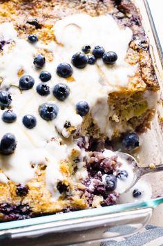 a casserole dish with blueberries and cream in it, ready to be eaten