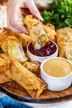 a person dipping sauce onto some food on a plate