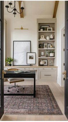 a home office with built - in shelving units and an area rug on the floor