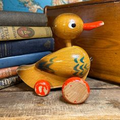 a wooden duck sitting on top of a table next to books