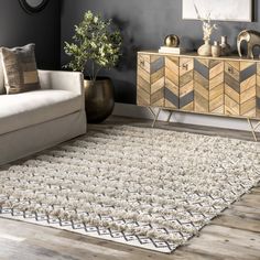 a living room with a couch, rug and sideboard in the middle of it