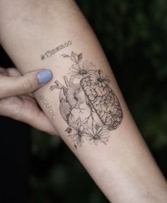 a woman's arm with a tattoo on it that has a heart and flowers