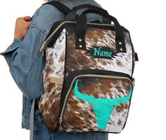 a person wearing a backpack with a cow print and name on the front, back side