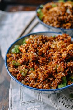 two bowls filled with rice and vegetables on top of a table