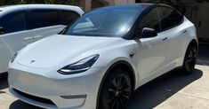 two white electric cars parked next to each other