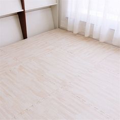 an empty room with white walls and wood flooring on the bottom level, next to a window