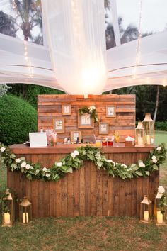 an outdoor bar decorated with greenery and candles