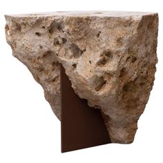 a large rock with a metal stand on it's side, against a white background