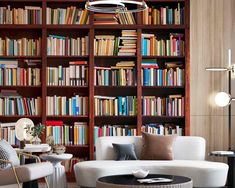 a living room filled with furniture and lots of bookshelves full of colorful books