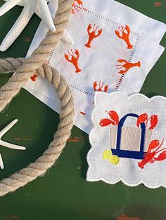 two napkins with hand prints on them next to a rope and starfish decorations