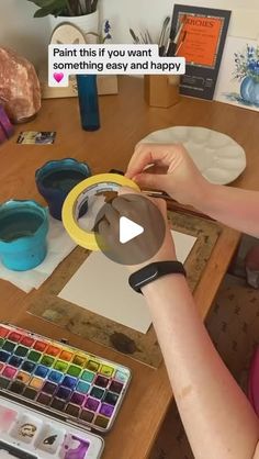 a woman is painting with her hands on the table