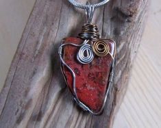 a wire wrapped heart pendant on a wooden surface