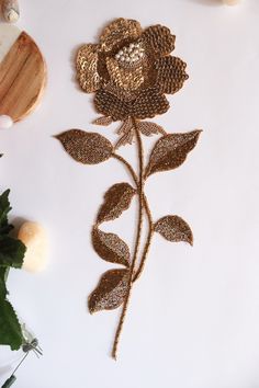 a flower made out of mesh sitting on top of a white table next to other items