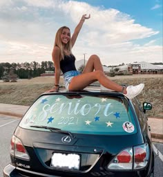 a woman sitting on top of a car with the word senior 2012 painted on it