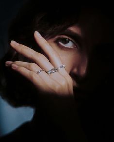 a close up of a person holding their hand to her face with the ring on it's finger