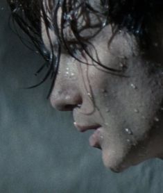 a close up of a person with wet hair and water droplets on his face, looking to the side