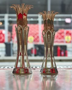 two glass vases sitting on top of a table