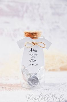 a glass jar filled with silver hearts and a tag that says, a day from our little miss