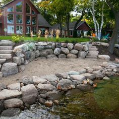 there is a stone path going up to the house by the water's edge