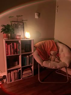 a teddy bear sitting in a chair next to a book shelf