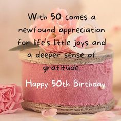 a pink birthday cake with flowers on it and the words happy 50th birthday written in white