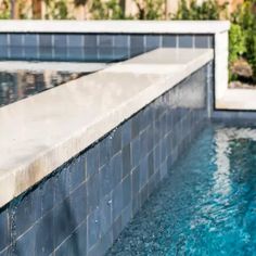 an empty swimming pool with blue tiles and water