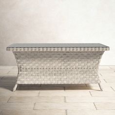 a white wicker trunk sitting on top of a tiled floor