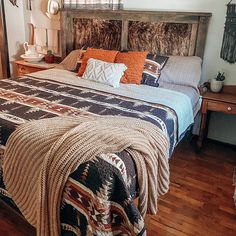 a bedroom with a bed, nightstands and pictures on the wall above it is decorated in native american style