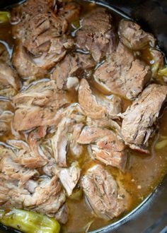 meat and vegetables cooking in a pot on top of the stove with some broth